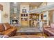 Living room with a large stone fireplace, built-in bar, and leather furniture at 39816 N 106Th Pl, Scottsdale, AZ 85262