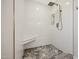 Walk-in shower with white tile, marble floor, and built-in shelf at 5019 E Cactus Rd, Scottsdale, AZ 85254