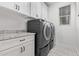 Bright laundry room with washer, dryer, and white cabinets at 5658 N 206Th Ln, Buckeye, AZ 85396