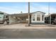 Mobile home exterior with carport, landscaping, and palm trees at 977 S Oxide Dr # 977, Apache Junction, AZ 85119