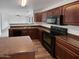 Kitchen with dark wood cabinets, granite countertops, and stainless steel appliances at 11325 W Hazelwood St, Phoenix, AZ 85037