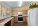 Well-lit kitchen featuring wood cabinets, updated appliances, and laminate floors at 1403 E Cherry Hills Dr, Chandler, AZ 85249