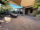 Relaxing backyard patio with shade sails, comfortable seating and lush landscaping at 15936 W Canterbury Dr, Surprise, AZ 85379