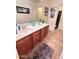 Clean bathroom with double sinks, a large mirror, and tiled floors at 15936 W Canterbury Dr, Surprise, AZ 85379