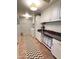 Laundry room with white cabinets, granite countertops, and tile flooring at 15936 W Canterbury Dr, Surprise, AZ 85379