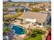 Aerial view showcasing a single-story home, pool, and lush landscaping at 17765 W Summit Dr, Goodyear, AZ 85338