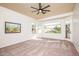 Spacious carpeted bedroom with ceiling fan and backyard view at 17765 W Summit Dr, Goodyear, AZ 85338