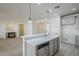 An open kitchen island featuring a sink and stainless steel dishwasher, adjoining living room with fireplace at 18526 E Swan Dr, Queen Creek, AZ 85142