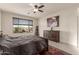 Main bedroom with large window, ceiling fan, and dresser at 21778 N 259Th Ln, Buckeye, AZ 85396