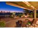 Evening view of backyard patio with fire pit, lounge chairs, and golf course view at 23206 N Del Monte Dr, Sun City West, AZ 85375