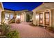 Inviting courtyard entry with brick pavers, lush landscaping, and elegant lighting at 23206 N Del Monte Dr, Sun City West, AZ 85375