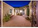 Charming courtyard entry with brick pavers, lush landscaping, and elegant lighting at 23206 N Del Monte Dr, Sun City West, AZ 85375