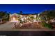 Beautiful Spanish style home with lush landscaping at night at 23206 N Del Monte Dr, Sun City West, AZ 85375