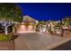 Luxury home with driveway and landscaped front yard at night at 23206 N Del Monte Dr, Sun City West, AZ 85375