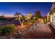 Night view of backyard landscaping with palm trees and rock features at 23206 N Del Monte Dr, Sun City West, AZ 85375