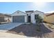 Single-story home with gray garage doors and a landscaped front yard at 26955 W Adam Ave, Buckeye, AZ 85396