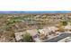 Stunning aerial view showcases a desert home, golf course, and tranquil lake nestled amid mountain views at 41512 N Tangle Ridge Ct, Anthem, AZ 85086
