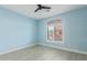 Light blue bedroom with ceiling fan, large window with shutters, and light wood flooring at 41512 N Tangle Ridge Ct, Anthem, AZ 85086