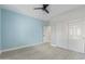 Light blue bedroom with ceiling fan, double door closet, and light wood flooring at 41512 N Tangle Ridge Ct, Anthem, AZ 85086