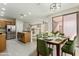 Dining area with green chairs and a view of the modern kitchen at 41512 N Tangle Ridge Ct, Anthem, AZ 85086