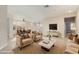 Open-concept living room with comfortable seating, a modern coffee table, and a view of the dining area at 41512 N Tangle Ridge Ct, Anthem, AZ 85086