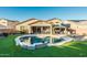 Inviting backyard oasis with sparkling pool, covered patio, and lush landscaping at 44049 W Palo Nuez St, Maricopa, AZ 85138