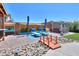 Landscaped backyard with patio, pool, and a wooden bridge at 44049 W Palo Nuez St, Maricopa, AZ 85138