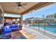 Covered patio with comfortable seating, ceiling fan, and access to the pool area at 44049 W Palo Nuez St, Maricopa, AZ 85138