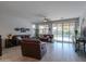 Open and spacious living area with leather furniture and access to the pool at 44049 W Palo Nuez St, Maricopa, AZ 85138