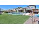 Relaxing kidney-shaped pool with artificial turf and a covered patio at 44049 W Palo Nuez St, Maricopa, AZ 85138