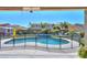 View of a kidney-shaped pool from a covered patio, showcasing a fenced backyard at 44049 W Palo Nuez St, Maricopa, AZ 85138