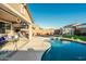 Relaxing patio area adjacent to a kidney-shaped pool, offering ample space for entertaining at 44049 W Palo Nuez St, Maricopa, AZ 85138