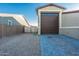 Side yard with gravel, a gate, and a large garage at 44049 W Palo Nuez St, Maricopa, AZ 85138