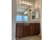 Bathroom vanity with granite countertop, dark wood cabinets, and large mirror at 5822 E Bramble Berry Ln, Cave Creek, AZ 85331