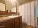 Bathroom with wood vanity, shower/tub combo, and a bird-themed shower curtain at 650 N Hawes Rd # 3702, Mesa, AZ 85207