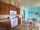 Kitchen with wood cabinets, white appliances, and an adjacent dining area at 650 N Hawes Rd # 3702, Mesa, AZ 85207
