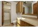 Bathroom with wood cabinets, granite countertop, and walk-in closet at 7150 N 64Th Pl, Paradise Valley, AZ 85253
