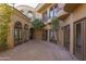 Charming brick courtyard with lush landscaping and arched entryways at 7150 N 64Th Pl, Paradise Valley, AZ 85253