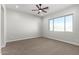 Spacious bedroom with ceiling fan and neutral carpeting at 10176 W Heather Dr, Arizona City, AZ 85123