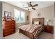 Bright bedroom with wood-toned furniture and ceiling fan at 1113 W Fir Tree Rd, Queen Creek, AZ 85140