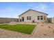 Landscaped backyard with artificial turf, paver patio, and a cozy fire pit for outdoor entertaining at 1167 W Chimes Tower Dr, Casa Grande, AZ 85122