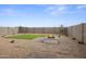 Backyard featuring pavers, artificial turf, gravel and a white fireplace at 1167 W Chimes Tower Dr, Casa Grande, AZ 85122