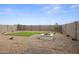Backyard featuring pavers, artificial turf, gravel and a white fireplace at 1167 W Chimes Tower Dr, Casa Grande, AZ 85122