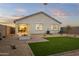 Charming backyard featuring an outdoor fire pit, artificial grass, and covered patio, perfect for entertaining at 1167 W Chimes Tower Dr, Casa Grande, AZ 85122