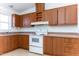Kitchen features wood cabinets, white appliances, and a corner sink at 12866 W Sun Ave, Eloy, AZ 85131