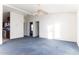 Living room with blue carpet, ceiling fan, and adjacent kitchen at 12866 W Sun Ave, Eloy, AZ 85131