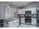 Bright kitchen features white cabinets, stainless steel appliances, and granite countertops at 14416 W Kiowa Trl, Surprise, AZ 85374