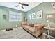 Light and bright game room with a brown leather couch and a ceiling fan at 17255 W Seldon Ln, Waddell, AZ 85355