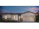Single-story home with tan exterior, brick accents, and a 2-car garage at 18144 W Tanglewood Dr, Goodyear, AZ 85338