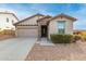Tan house with stone accents, two-car garage, and landscaped yard at 29715 N 119Th Ln, Peoria, AZ 85383